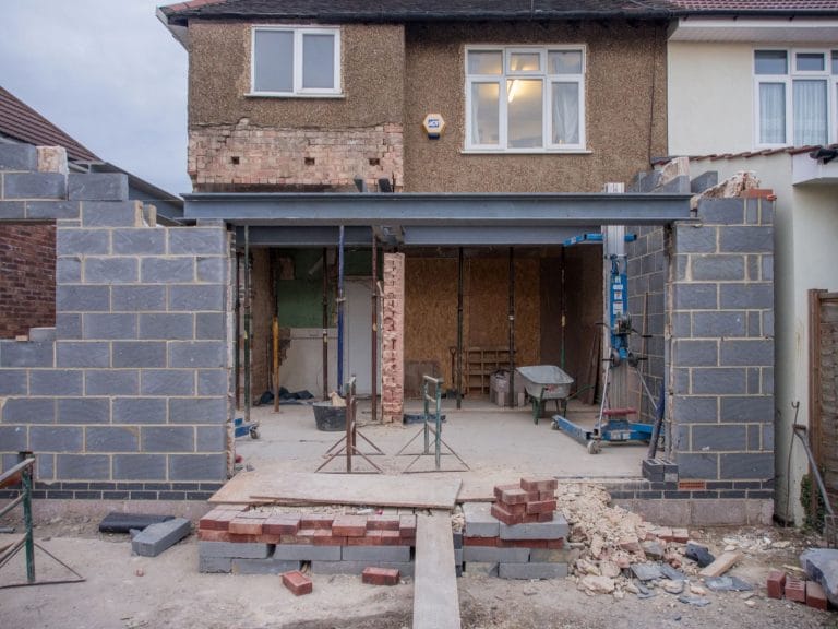 Chantier d extension à l arrière d une maison individuelle, murs en parpaings et poutre métallique